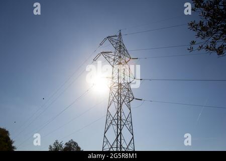 Ein elektrischer Turm in den Bergen, der das bergige Gelände überwindet, um Strom in die Industrie und in unsere Häuser zu bringen. Grüne Energie Stockfoto