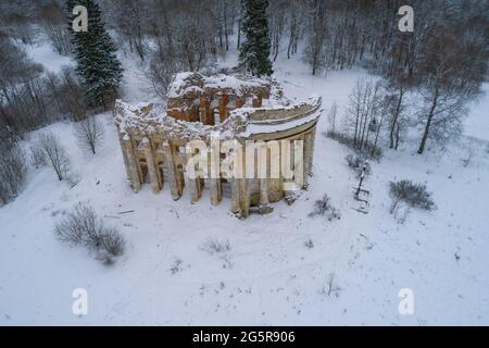 Blick auf die Ruinen der alten Kirche der Heiligen Dreifaltigkeit im Dorf des Fünften Berges an einem bewölkten Februartag (Luftaufnahme). Region Leningrad Stockfoto