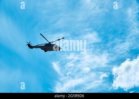 Urla, İzmir, Türkei - Juni, 2021: Türkischer Hubschrauber der Luftwaffe Sikorsky fliegt gegen blauen Himmel und Wolken vor dem Hintergrund. Stockfoto