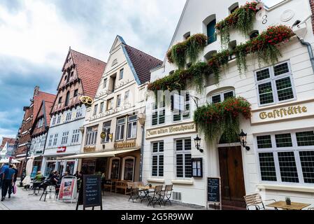 Lunenburg, Deutschland - 17. August 2019: Einkaufsstraße mit typischen Stadthäusern, Terrassenbar, Hotel, Restaurant, Geschäften und Menschen in Lunenburg, Stockfoto