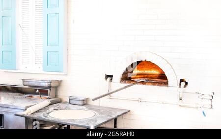 Pizzen oder Pita Brot backen und kochen in offenem Brennholz typischen Backstein weißen Ofen Stockfoto