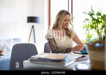 Junge Frau, die von zu Hause aus arbeiten Stockfoto