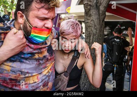 Ankara, Türkei. Juni 2021. Während der Pride Week march wird ein Demonstranten, der durch Tränengas, das die Polizei auf Demonstranten schleudert, verletzt wurde, von einer Frau unterstützt. Die Polizei greift mit Tränengas ein und hält mehrere LGBTI-Demonstranten fest, die während der Pride Week mit Transparenten, Plakaten und Fahnen durch Ankara marschieren. (Foto von Tunahan Turhan/SOPA Images/Sipa USA) Quelle: SIPA USA/Alamy Live News Stockfoto