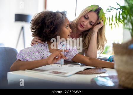 Mutter Tochter helfen bei den Hausaufgaben Stockfoto