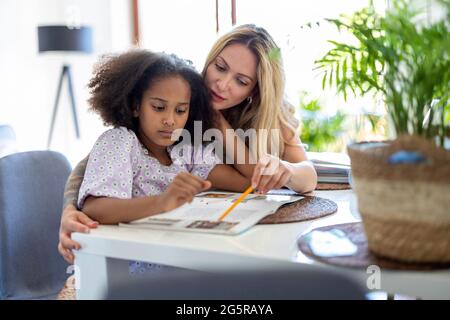 Mutter Tochter helfen bei den Hausaufgaben Stockfoto