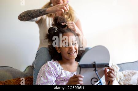 Mutter stylen die Haare der Tochter zu Hause Stockfoto