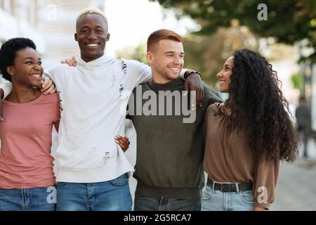 Internationale Gruppe von Studenten umarmt, während sie auf der Straße stehen Stockfoto