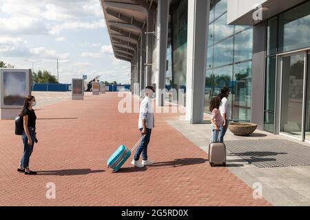 Reisende, zu Fuß im Flughafen, Seitenansicht. Soziale Distanz Stockfoto