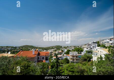 Stadtbild von Athen in Griechenland. Draufsicht. Urbane Architektur und viele grüne Bäume. Hügelige Gegend. Sonnentag. Stockfoto