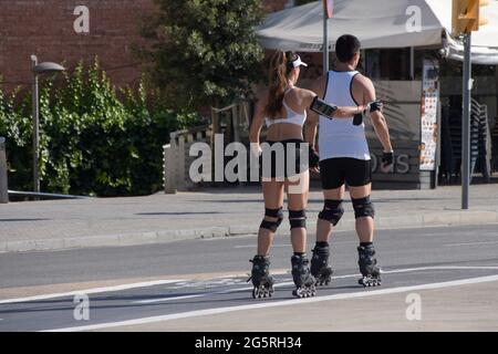Rückansicht eines jungen Paares mit Inline-Skates in einer Straße. Stockfoto