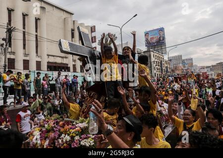 Philippinisch-katholische Anhänger schließen sich dem Segen der Repliken der Schwarzen Nazaräer vor dem Fest des Schwarzen Nazareners in Manila, Philippinen, an. Stockfoto