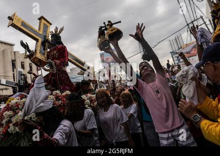 Philippinisch-katholische Anhänger schließen sich dem Segen der Repliken der Schwarzen Nazaräer vor dem Fest des Schwarzen Nazareners in Manila, Philippinen, an. Stockfoto