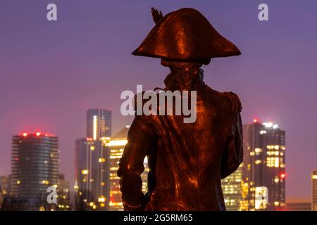 England, London, Greenwich, Silouette der Lord Nelson Statue und die Canary Wharf Skyline bei Nacht Stockfoto