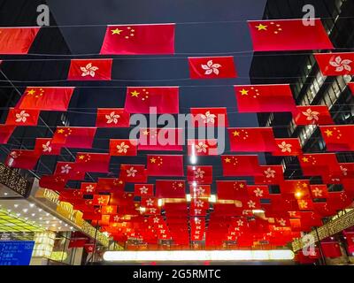 Hongkong, China. Juni 2021. Chinas Nationalflaggen und die Flaggen der Sonderverwaltungsregion Hongkong zur Feier des 24. Jahrestages der Rückkehr Hongkongs nach China in Tsim Sha Tsui. Hongkong feiert am 1. Juli den Jahrestag der Rückkehr nach China mit einer Flagge in Tsim Sha Tsui. In diesem Jahr ist der 1. Juli auch der gleiche Tag für die Feierlichkeiten zum 100. Jahrestag der Kommunistischen Partei Chinas in Peking. Kredit: SOPA Images Limited/Alamy Live Nachrichten Stockfoto