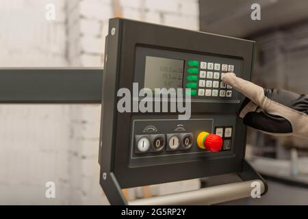 Der Prozess der Programmierung einer CNC-Maschine. Eingabe von Daten in eine computergesteuerte Maschine, Starten der CNC-Gravur, Kontrollbildschirm. Stockfoto