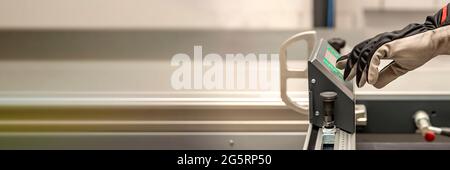 Ein Zimmermann arbeitet an einer Holzbearbeitungsmaschine. In einer Schreinerei arbeitet ein Zimmermann an Holzbearbeitungsmaschinen. Stockfoto