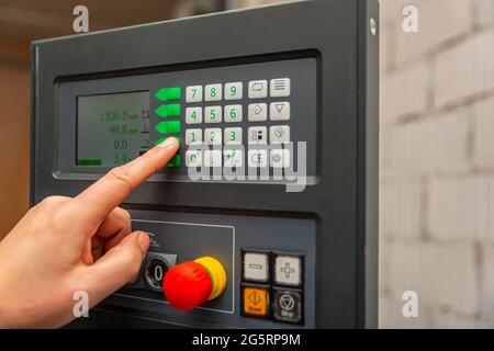 Der Prozess der Programmierung einer CNC-Maschine. Eingabe von Daten in eine computergesteuerte Maschine. CNC-Maschinenbediener gibt Daten ein. Stockfoto