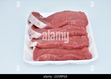 Frisches, knochenloses Lammfleisch in Scheiben geschnittene Stücke auf weißem Hintergrund, Nahaufnahme, Flankenportion Stockfoto