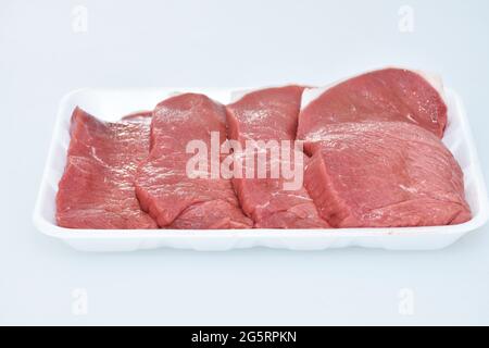 Frisches, knochenloses Lammfleisch in Scheiben geschnittene Stücke auf weißem Hintergrund, Nahaufnahme, Flankenportion Stockfoto
