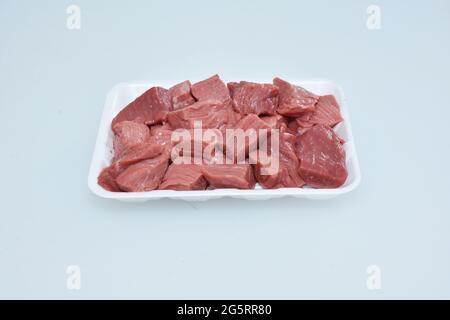 Frisches, knochenloses Lammfleisch, gehackte Würfel auf dem Teller, rohe Hammelstücke aus der Nähe, Metzgerschnitt Stockfoto