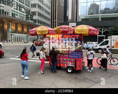 Hot Dog Vendor hat eine erstklassige Lage an der Ecke der 6th Avenue und 42nd Street am Haupteingang zum Bryant Park in Midtown Manhattan. Stockfoto