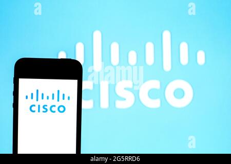 In dieser Abbildung wird ein Logo von Cisco Systems auf einem Smartphone mit einem Logo von Cisco Systems im Hintergrund angezeigt. Stockfoto