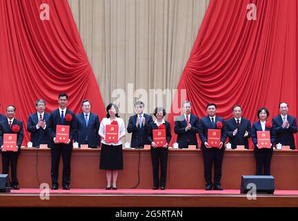 (210629) -- PEKING, 29. Juni 2021 (Xinhua) -- Wang Huning, Mitglied des Ständigen Ausschusses des Politbüros des Zentralkomitees der Kommunistischen Partei Chinas (KPCh) und Mitglied des Sekretariats des Zentralkomitees der KPCh, Und Zhao Leji, Mitglied des Ständigen Ausschusses des Politischen Büros des Zentralkomitees der KPCh und Sekretär der Zentralkommission der KPCh für Disziplinarinspektion, überreicht Auszeichnungen an die Preisträger der Titel herausragender Parteimitglieder, vorbildlicher Parteiarbeiter, Und fortgeschrittene Parteiorganisationen auf Gemeindeebene aus dem ganzen Land in der Großen Halle von Stockfoto