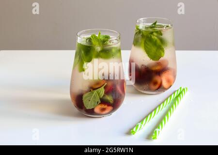 Kalte Getränke in einem Glas. Kirschen Minzlimonade. Mojito-Coctail. Erfrischungsgetränk mit Eis im Sommer. Stockfoto
