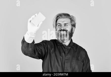 Spring Reinigung Service. Mit Schwamm für die Reinigung. Ehemann sauberes Haus. Hygiene und Reinheit. Bärtiger Mann tragen Gummihandschuhe. Reife Hausmeister in Uniform Stockfoto