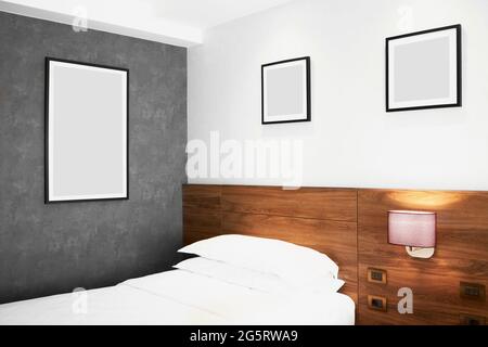 Modernes Schlafzimmer mit leeren Bildern an der Wand Stockfoto