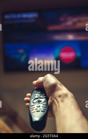 Männliche Hand, die TV-Fernbedienung. Stockfoto