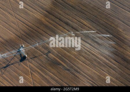 Luftaufnahme über das zentrale Schwenk-Bewässerungssystem, das Kulturen sprüht. Farm-Konzept, moderne Bewässerungsausrüstung, Landwirtschaft Textur. Stockfoto