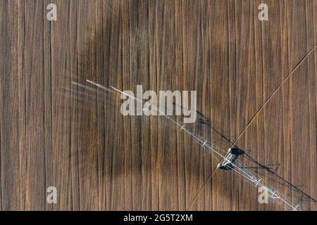 Luftaufnahme über das zentrale Schwenk-Bewässerungssystem, das Kulturen sprüht. Farm-Konzept, moderne Bewässerungsausrüstung, Landwirtschaft Textur. Stockfoto