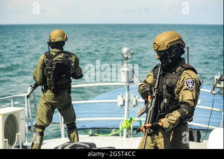 Acajutla, El Salvador. Juni 2021. Soldaten der Spezialeinheiten bewachen ein Schiff in einem Infiltrationsbohrer. Mitglieder des Anti-Terror-Spezialkommandos von El Salvador, die Teil der Spezialeinheiten der Armee sind, trainieren als Teil einer Operation, die auf den Drogenhandel abzielt. El Salvador ist Teil des Drogenhandels, der die Vereinigten Staaten erreichen will. Zwischen 2015 und 2018 wurden etwa 37.3 Tonnen Kokain konfisziert. Kredit: SOPA Images Limited/Alamy Live Nachrichten Stockfoto