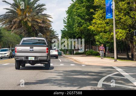 Gainesville, USA - 27. April 2018: Straßenautos in der Innenstadt von Florida mit dem UF-Campus der Universität von Florida, wo Studenten auf dem Bürgersteig laufen Stockfoto