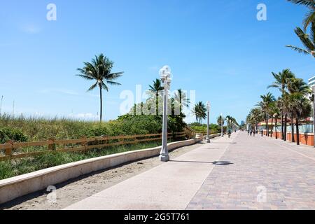 Hollywood, USA - 6. Mai 2018: Strandspaziergang in Florida Miami mit sonnigem Tag und Spaziergängen auf der Promenade durch Restaurants und Palmen Stockfoto