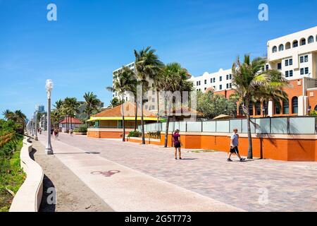 Hollywood, USA - 6. Mai 2018: Strandspaziergang in Florida an sonnigen Tagen und Menschen, die an Restaurants und Palmen entlang der Promenade spazieren Stockfoto