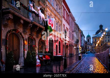 Lviv, Ukraine - 28. Dezember 2019: Lvov Altstadt rynok Marktplatz im Winter Weihnachten in der Nacht mit Dekorationen und Kirche auf der Straße Stockfoto