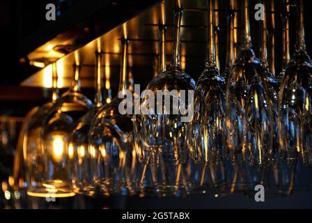 Eine Reihe von Weingläsern, die in einer Bar hängen Stockfoto