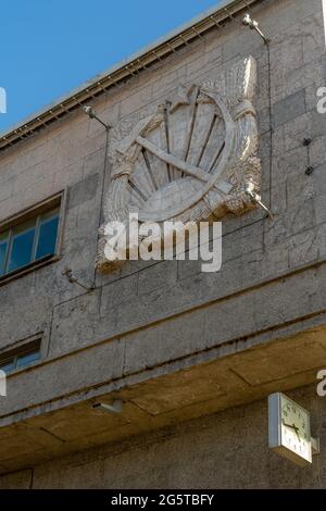 Hammer- und Sichelemblem, die auf der Fassade des Narvsky-Hauses der Sowjets, des Staatssymbols der UdSSR, Sankt Petersburg, Russland geschnitzt sind Stockfoto