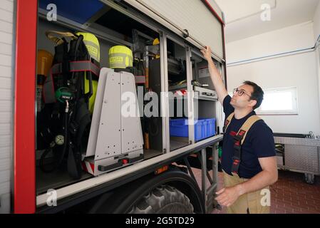 16. Juni 2021, Schleswig-Holstein, Helgoland: Felix Vorndran von der Freiwilligen Feuerwehr Bergisch-Gladbach überprüft während seines Dünendienstes auf der Düne der Hochseeinsel Helgoland die Ausrüstung des Einsatzfahrzeugs in der Feuerwehr. Feuerwehrleute aus ganz Deutschland können auf der Hochseeinsel Helgoland das angenehme mit dem Nützlichen während der Saison verbinden. Die Gemeinde sucht nach der Sicherung des Brandschutzes auf der Düne freiwillige Feuerwehrkameraden und -Genossen, die mit Ihrem Einsatz die touristische Nutzung der Düne aufrechterhalten. Die Feuerwehrmänner aus dem m Stockfoto