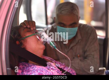 Neu-Delhi, Indien. April 2021. Getröstet von einem Familienmitglied erhält ein Covid-19-Patient Sauerstoff, der von der Sikh-Organisation im Großraum Neu-Delhi bereitgestellt wird. Quelle: Vijay Pandey/ZUMA Wire/Alamy Live News Stockfoto