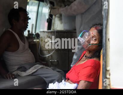 Guwahati, Indien. Mai 2021. Eine Frau mit Atembeschwerden inhaliert Medikamente mit Hilfe der Vernebler-Sauerstoffmaske in einem Krankenwagen im MMCH-Krankenhaus in Guwahati. Quelle: David Talukdar/ZUMA Wire/Alamy Live News Stockfoto