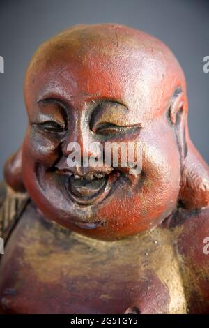 Traditionelle Holzstatue des chinesischen Buddha isoliert auf dunklem Hintergrund Stockfoto