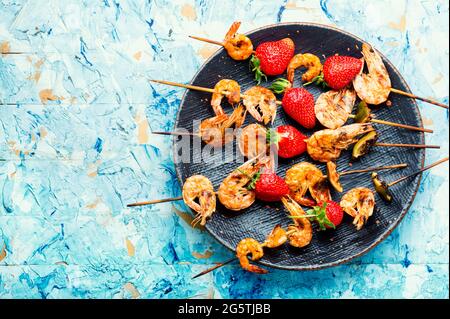 Appetitlich gegrillte Garnelen auf Holzspießen mit Erdbeeren.Garnelen bbq Stockfoto