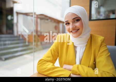 Nahaufnahme eines Porträts einer muslimischen Frau mit Kopftuch im Café Stockfoto