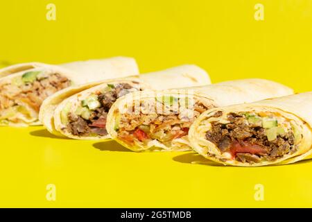 Dönerrolle Shawarma mit Huhn und Gemüse auf gelb Stockfoto