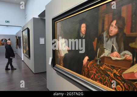 BELGIEN. FLANDERN. BRÜGGE. MANN, DER SICH IM GROENINGEMUSEUM EINIGE GEMÄLDE AUS DER PRIMITIVEN FLÄMISCHEN ZEIT ANSIEHT. AUF DEN ERSTEN BLICK EIN GEMÄLDE VON JAC Stockfoto