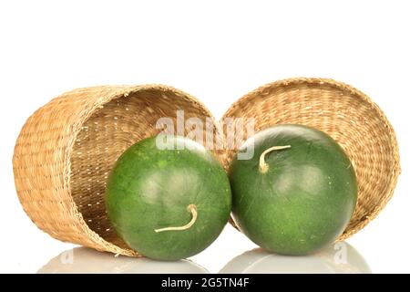 Zwei dunkelgrüne Bio-Wassermelonen mit einer Strohbox, Nahaufnahme, auf weißem Hintergrund. Stockfoto