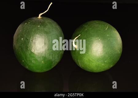 Zwei ganze dunkelgrüne organische Wassermelonen, Nahaufnahme, auf schwarzem Hintergrund. Stockfoto